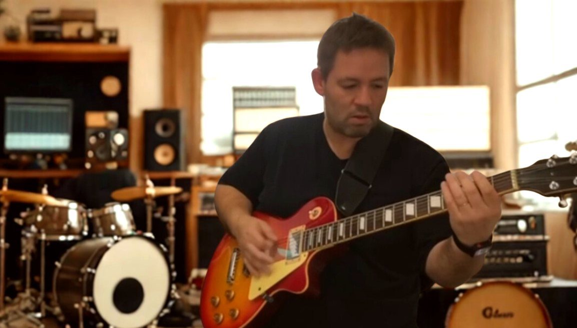 Denis Delphin em seu estúdio, professor de mentoria online de guitarra