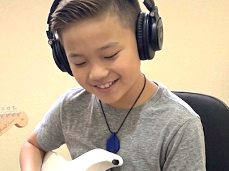 Eric, 10 anos, tocando guitarra nas aulas com Denis Delphin